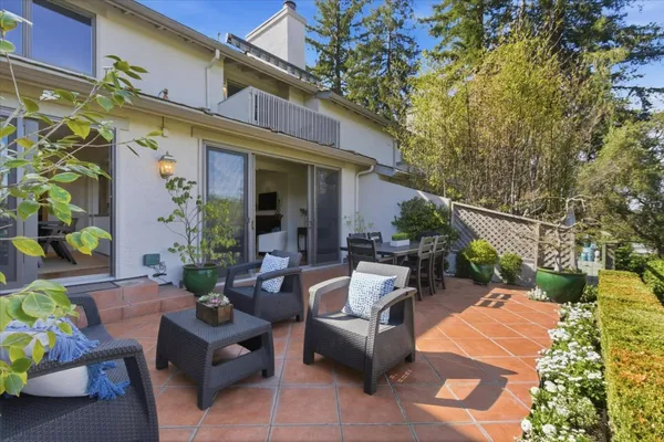 a view of a patio with couches table and chairs and potted plants