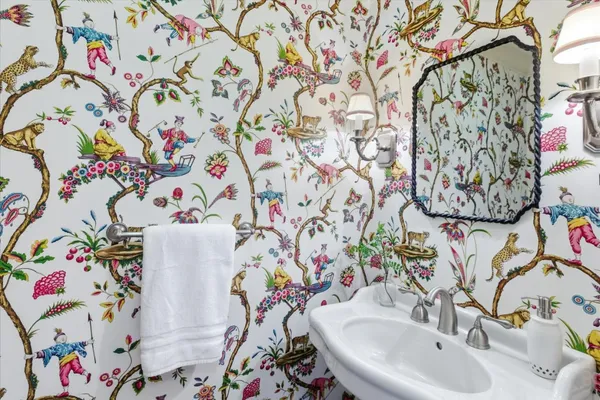 a bathroom with a sink and mirror with painted walls