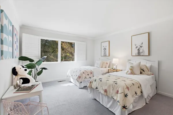 a bedroom with two beds and a large window
