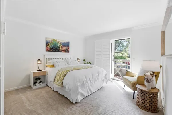 a bedroom with a bed a couch and a window