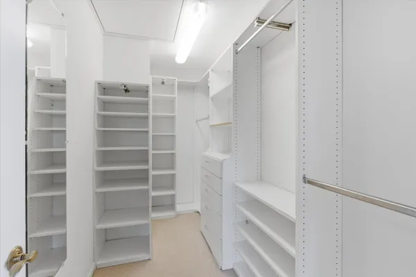 a view of walk in closet with empty racks