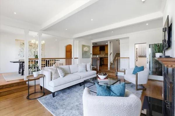 a living room with furniture and a view of kitchen