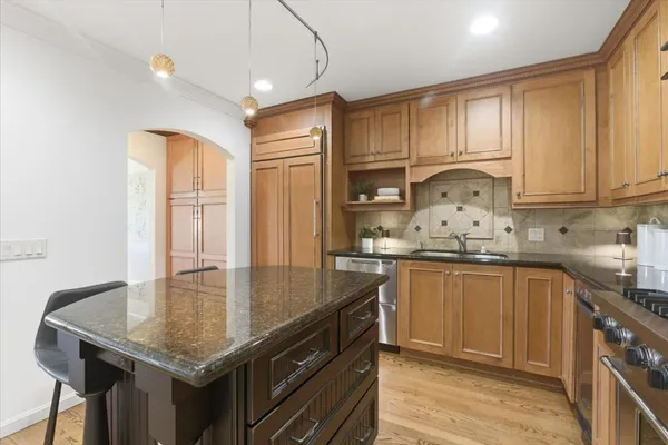 a kitchen with granite countertop a sink a stove and cabinets