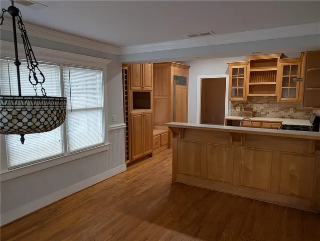 a view of a hallway with wooden floor and chandelier