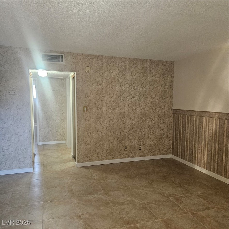 350 East Desert Inn Road, Unit C203 Las Vegas, NV 89109 - Photo 25 of 35 Unfurnished room with a textured ceiling and wallpapered walls