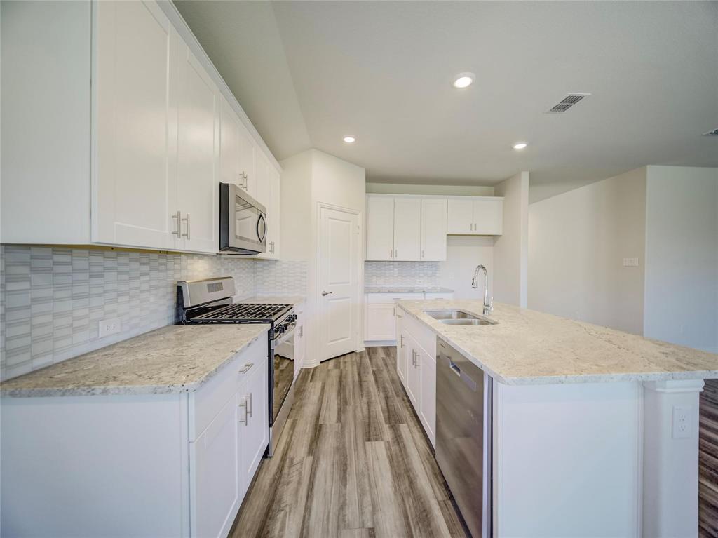 3405 Kingsgarden Road Denton, TX 76207 - Photo 5 of 37 a kitchen with a sink stove and cabinets