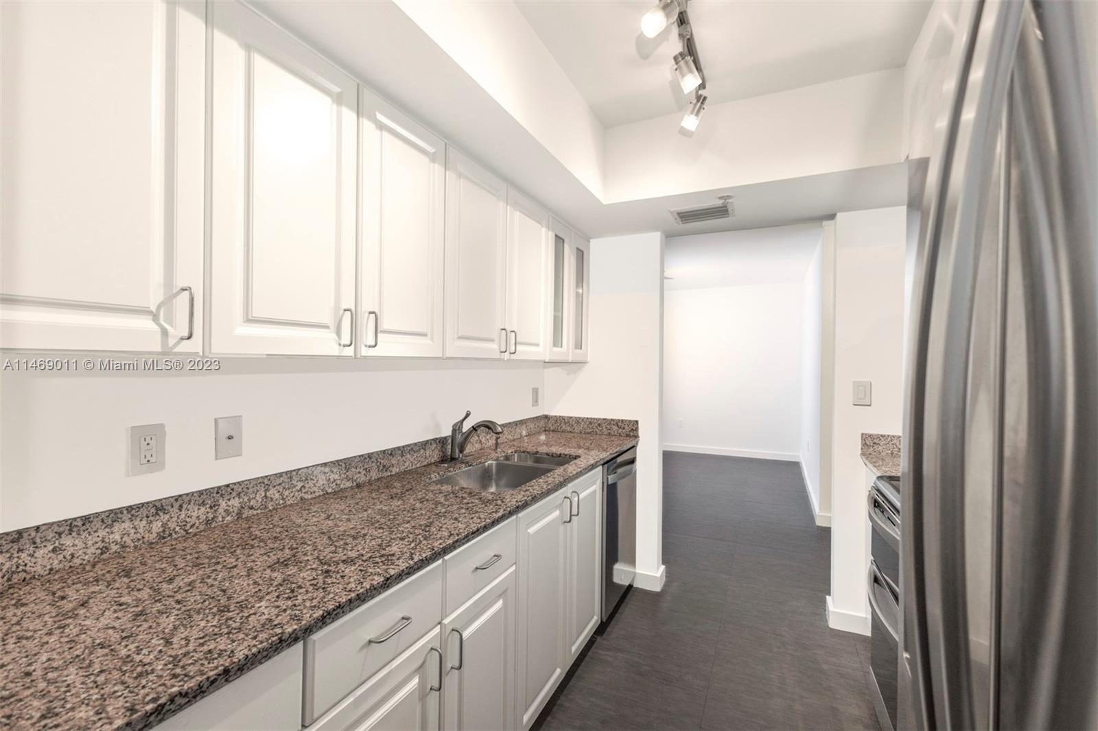 90 Alton Road, Unit 2807 Miami Beach, FL 33139 - Photo 22 of 30 a kitchen with stainless steel appliances granite countertop a sink and a refrigerator