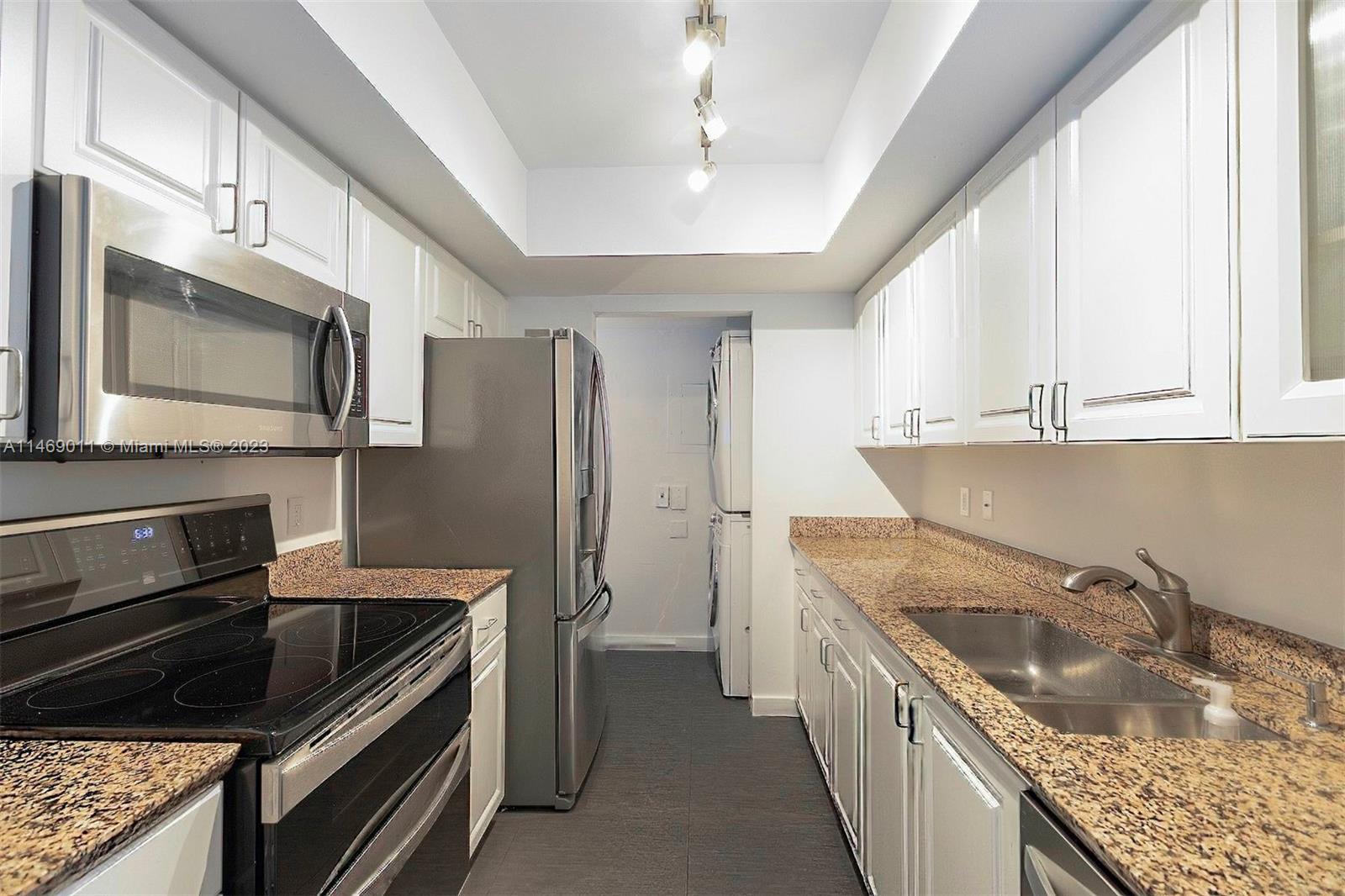 90 Alton Road, Unit 2807 Miami Beach, FL 33139 - Photo 5 of 30 a kitchen with a sink stove and refrigerator