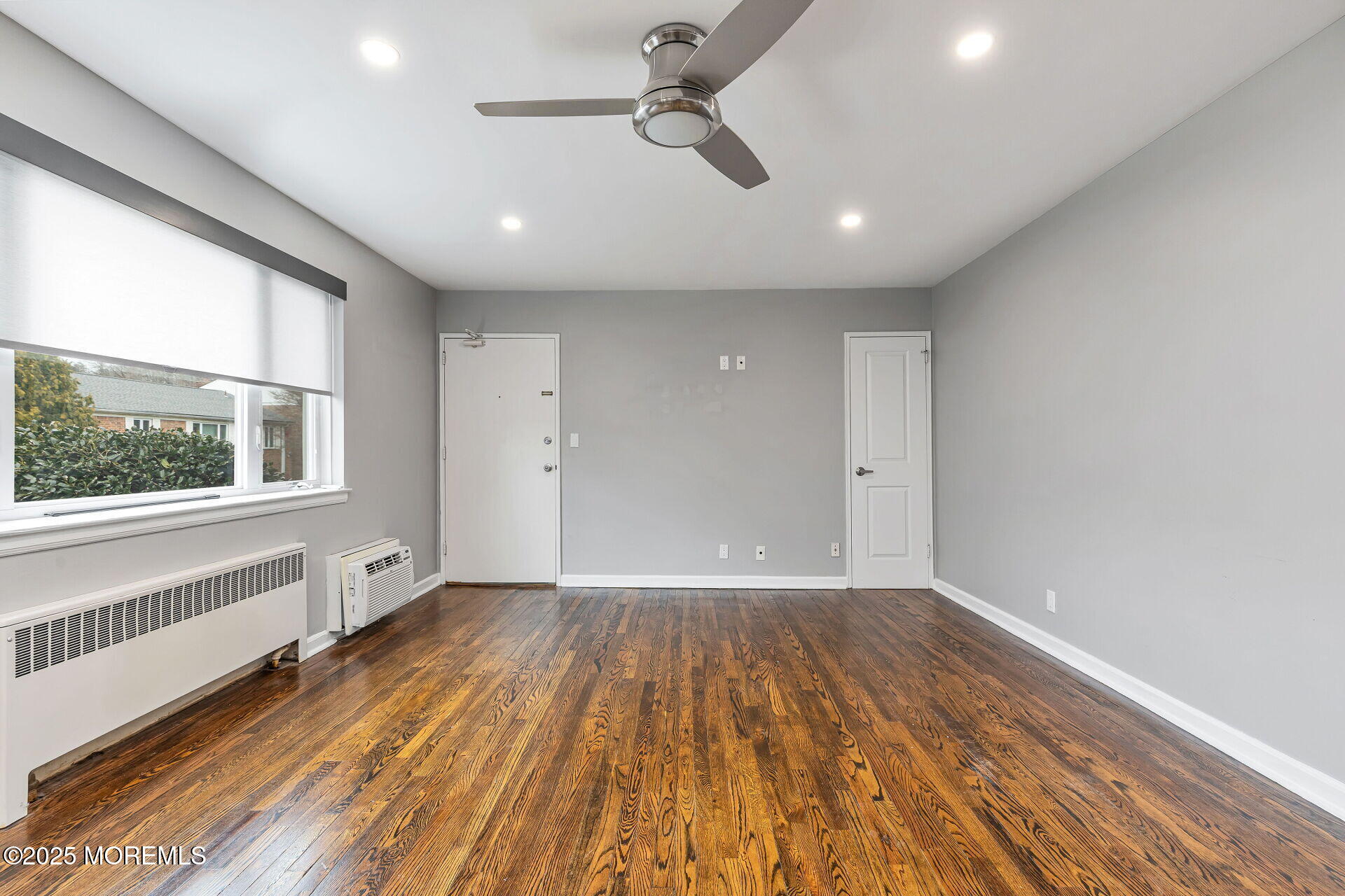 293 Spring Street, Unit 15D Red Bank, NJ 07701 - Photo 6 of 28 an empty room with wooden floor and windows