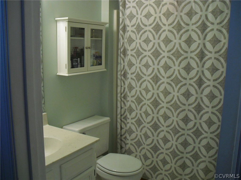 5501 Chatmoss Road Midlothian, VA 23112 - Photo 11 of 29 a white toilet sitting next to a shower curtain