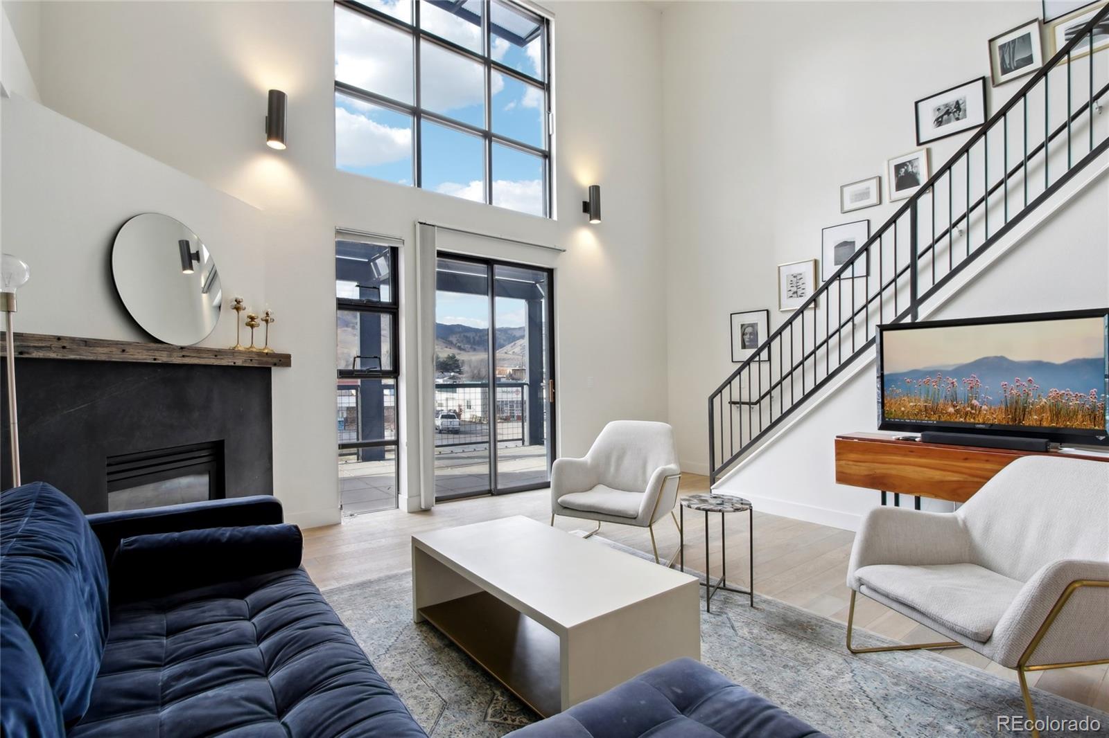 4520 Broadway, Unit 208 Boulder, CO 80304 - Photo 4 of 39 a living room with furniture a fireplace and a chandelier