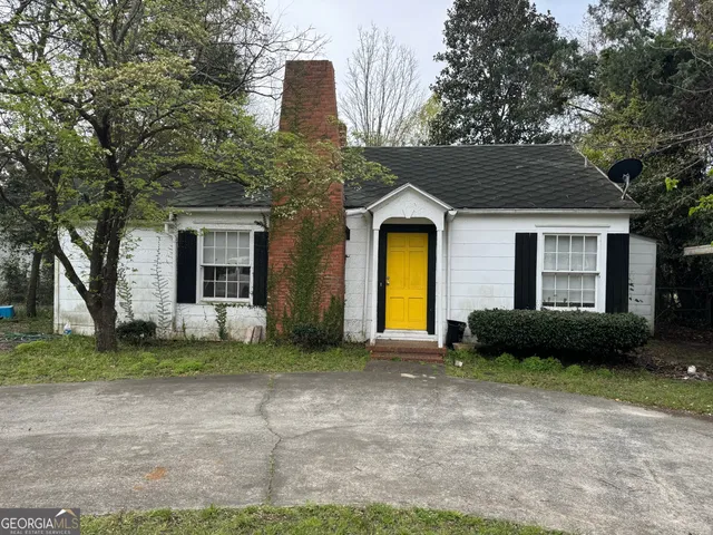 a front view of a house with a garden and plants