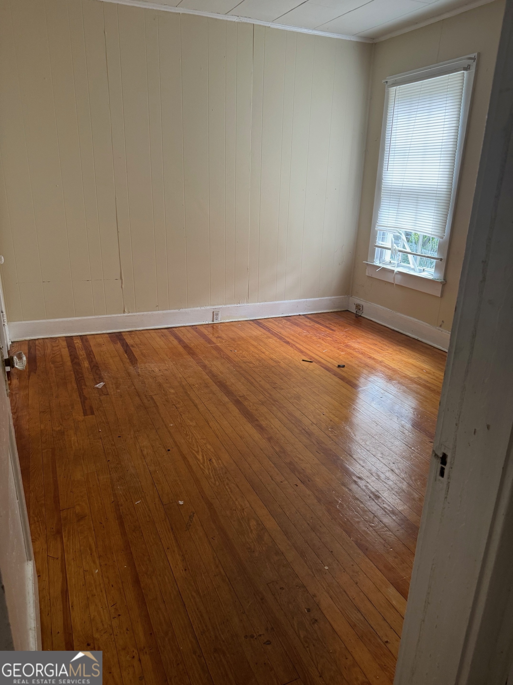 904 Euclid Street Dublin, GA 31021 - Photo 6 of 7 an empty room with wooden floor and windows