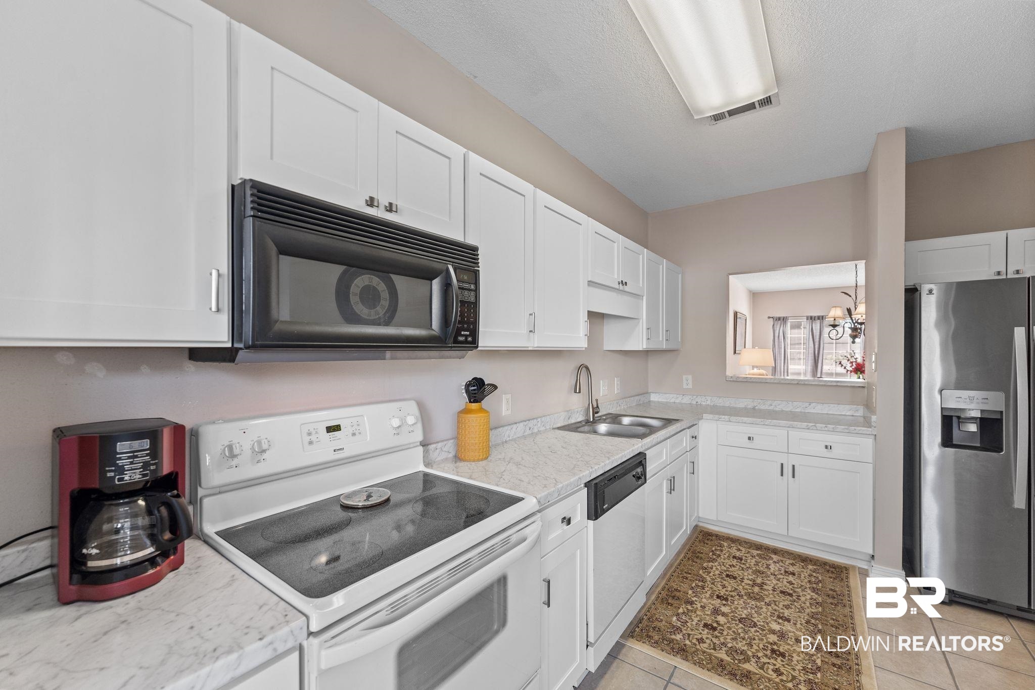 2651 South Juniper Street, Unit 203 Foley, AL 36535 - Photo 11 of 22 Kitchen featuring white appliances, light countertops, white cabinetry, a chandelier, and light tile patterned flooring