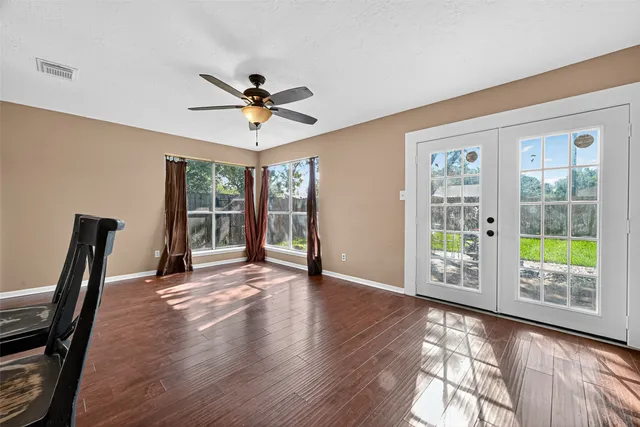 a view of an empty room with a window and wooden floor