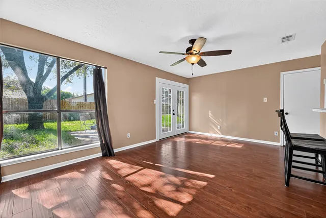 a view of a room with wooden floor and a ceiling fan