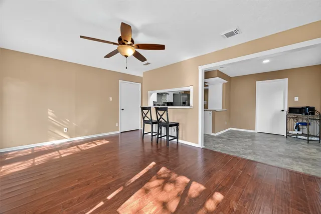 a view of a livingroom with furniture a ceiling fan and wooden floor