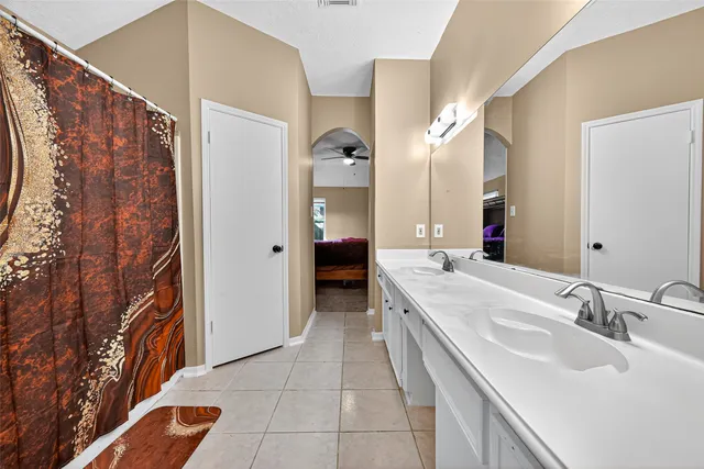 a bed sitting in a room next to a window and a chandelier