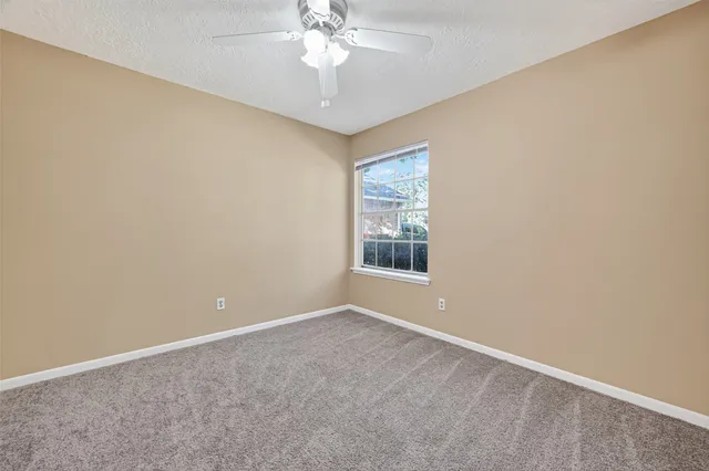 an empty room with a chandelier fan and closet