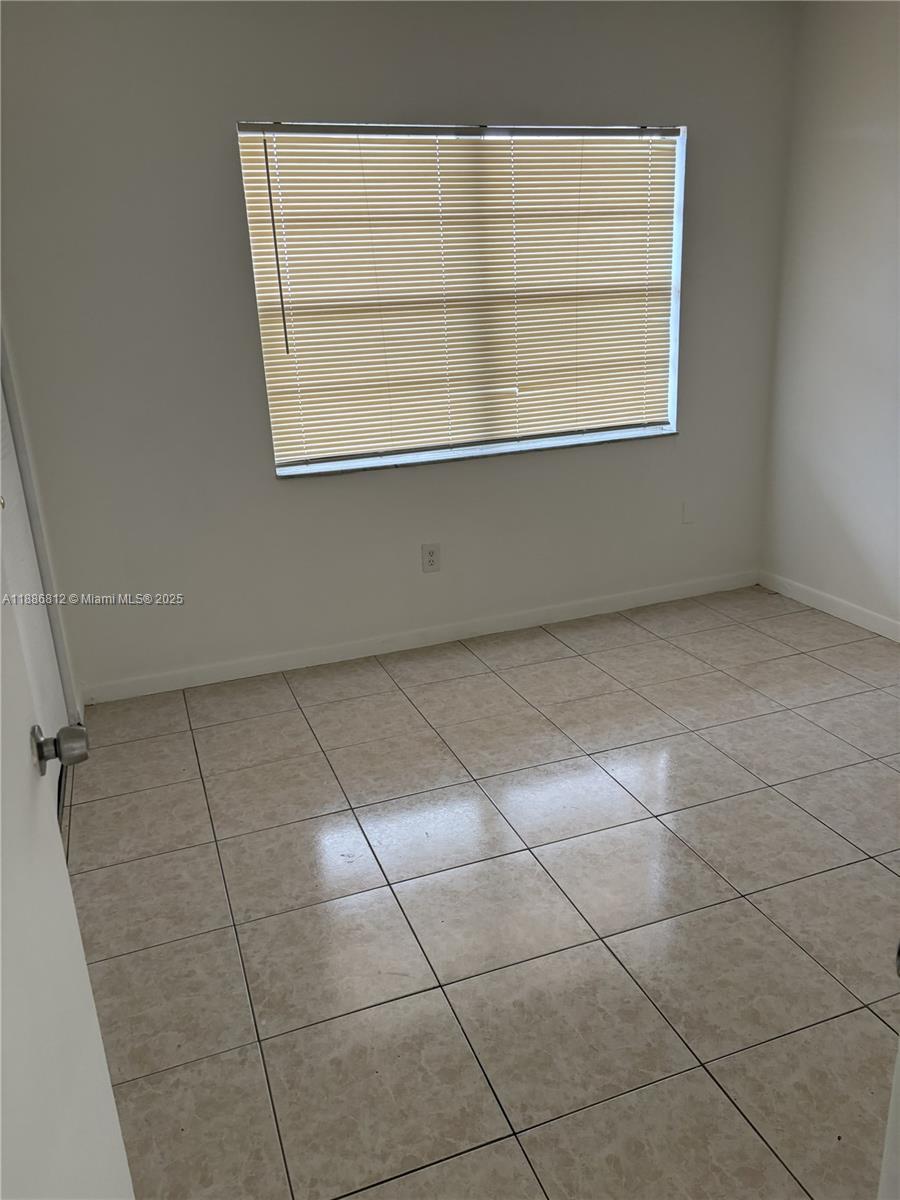 3675 West 11th Avenue, Unit 319 Hialeah, FL 33012 - Photo 14 of 15 a view of an empty room with a window