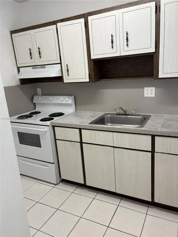 a kitchen with granite countertop white cabinets stainless steel appliances and a sink