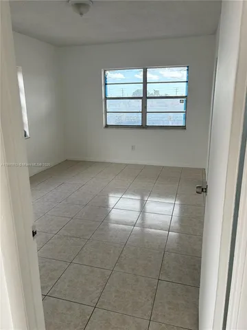 an empty room with windows and entrance