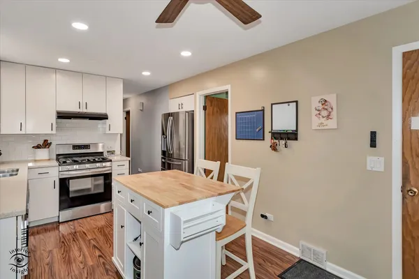 a kitchen with a appliances a refrigerator and a stove top oven