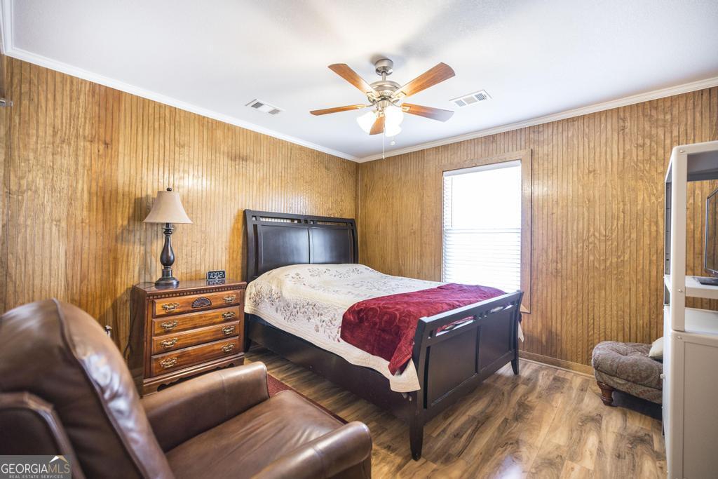 177 Lovett Scott Road Adrian, GA 31002 - Photo 18 of 37 a bedroom with a bed and wooden floor