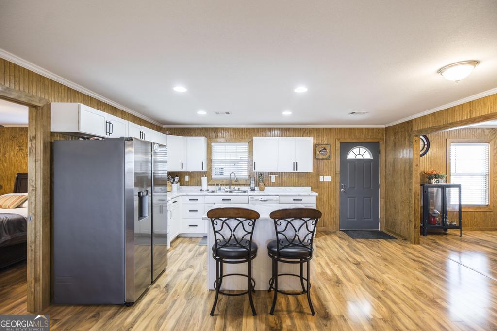 177 Lovett Scott Road Adrian, GA 31002 - Photo 9 of 37 a kitchen with stainless steel appliances granite countertop a refrigerator a sink a stove and island with wooden floor