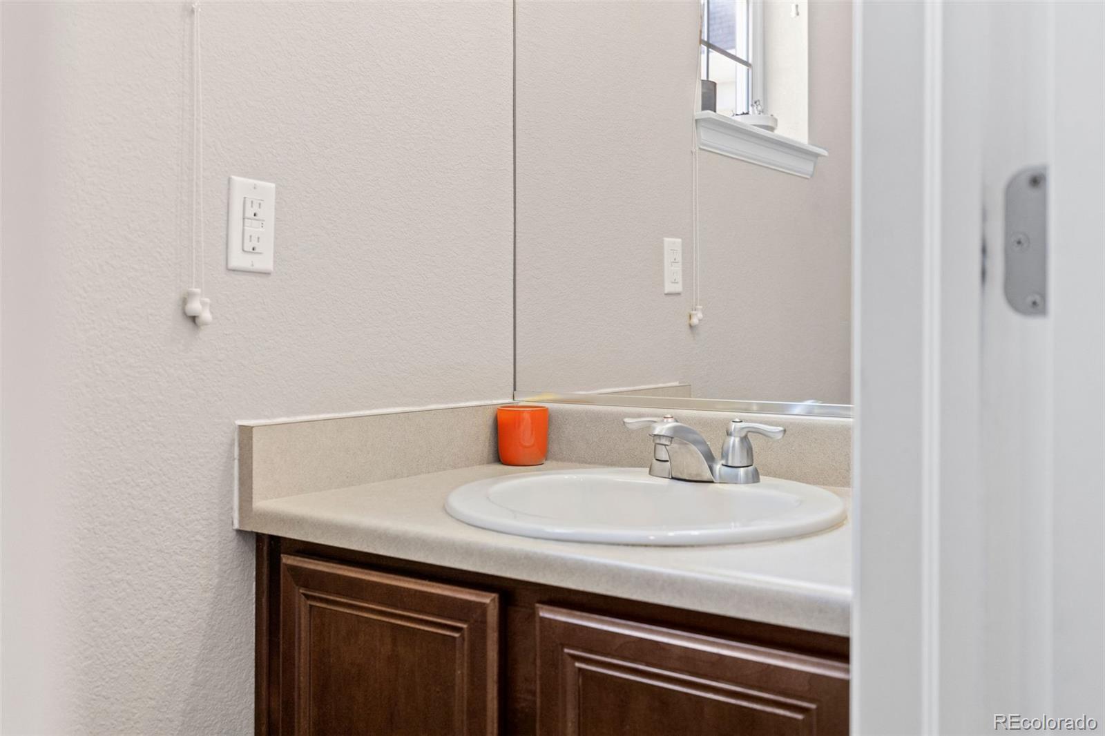 10039 Buttesfield Street Firestone, CO 80504 - Photo 11 of 35 a bathroom with a sink and a mirror