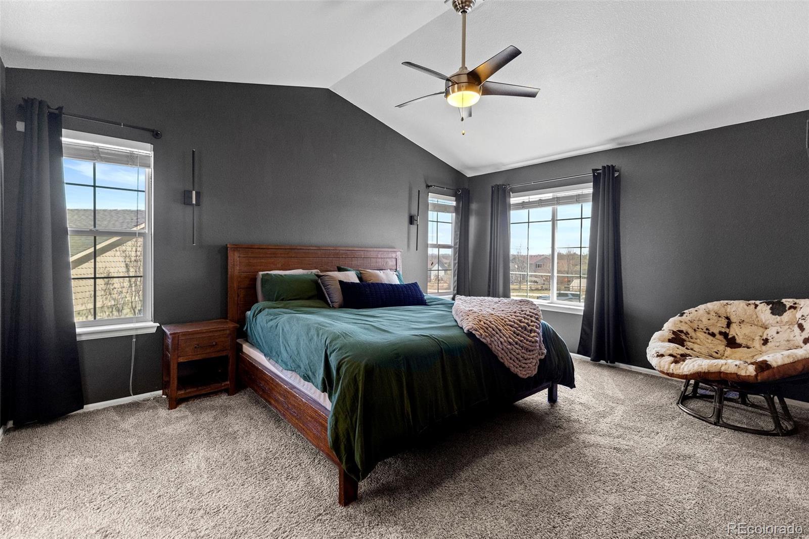10039 Buttesfield Street Firestone, CO 80504 - Photo 12 of 35 a bedroom with a bed window and a chandelier