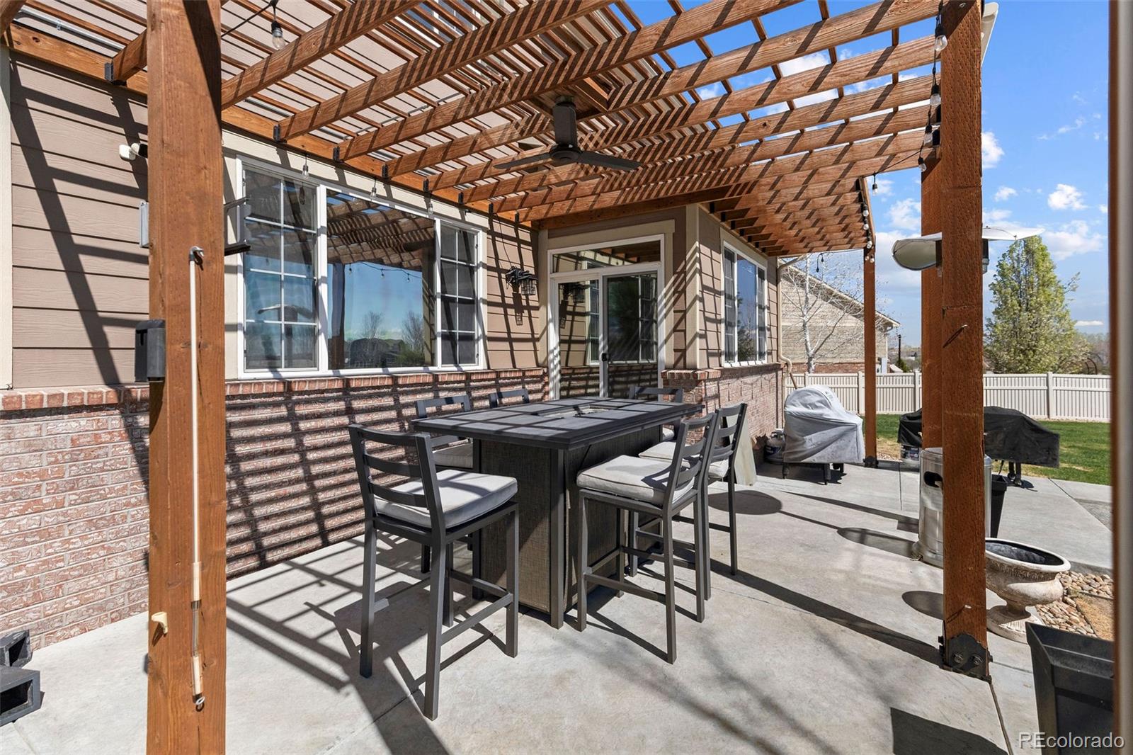 10039 Buttesfield Street Firestone, CO 80504 - Photo 27 of 35 a view of a patio with table and chairs with wooden floor and fence