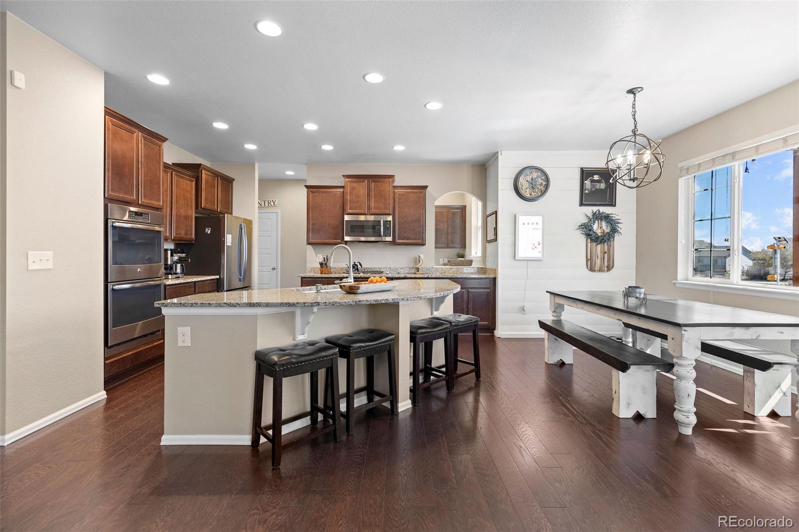10039 Buttesfield Street Firestone, CO 80504 - Photo 6 of 35 a kitchen with stainless steel appliances kitchen island granite countertop a large island in the center