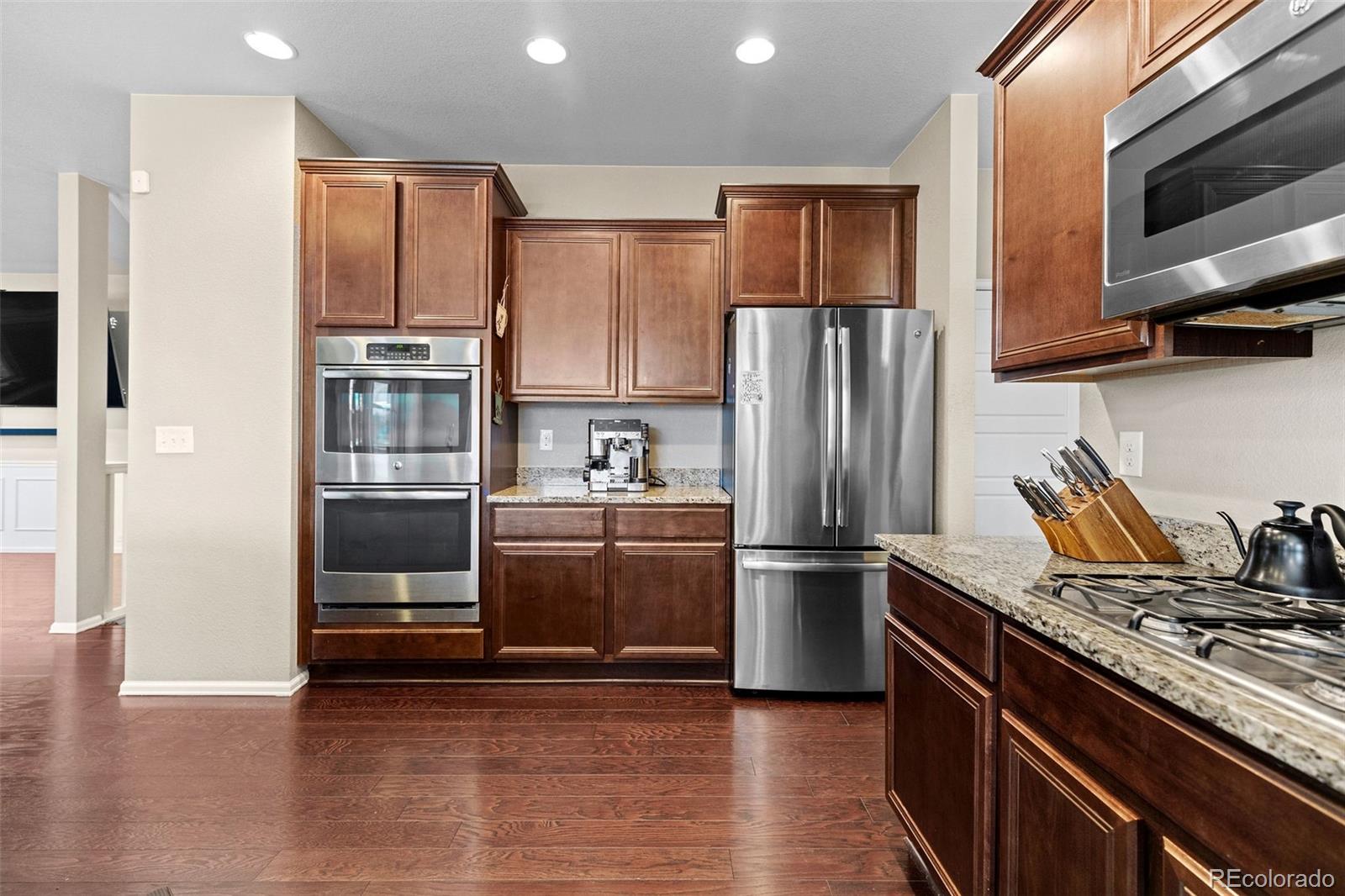 10039 Buttesfield Street Firestone, CO 80504 - Photo 7 of 35 a kitchen with stainless steel appliances and wooden floor