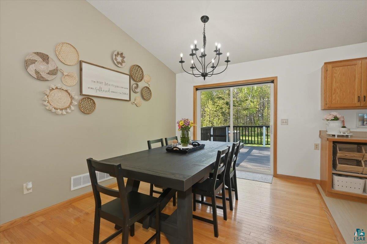 47 Amy Lane Esko, MN 55733 - Photo 11 of 33 Dining area with vaulted ceiling, wood-finish flooring, and direct access to an outdoor deck
