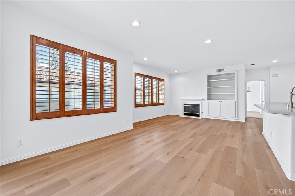 447 Ridgeway Irvine, CA 92620 - Photo 28 of 88 a view of empty room with wooden floor and kitchen view