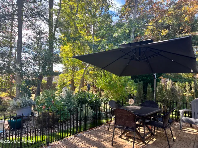 a view of a patio with table and chairs under an umbrella