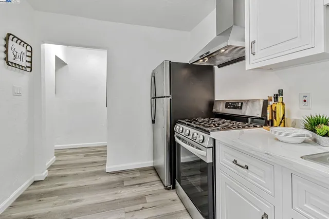 a kitchen with stainless steel appliances white cabinets and wooden floor