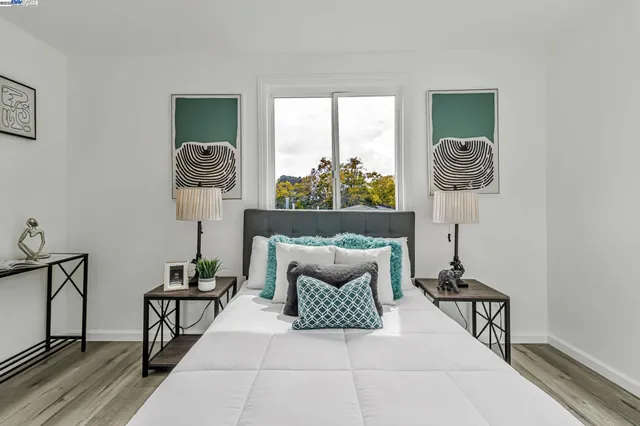 a bedroom with a bed and a painting on the wall