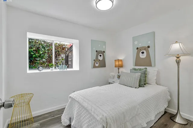 a bedroom with a bed and painting on the wall