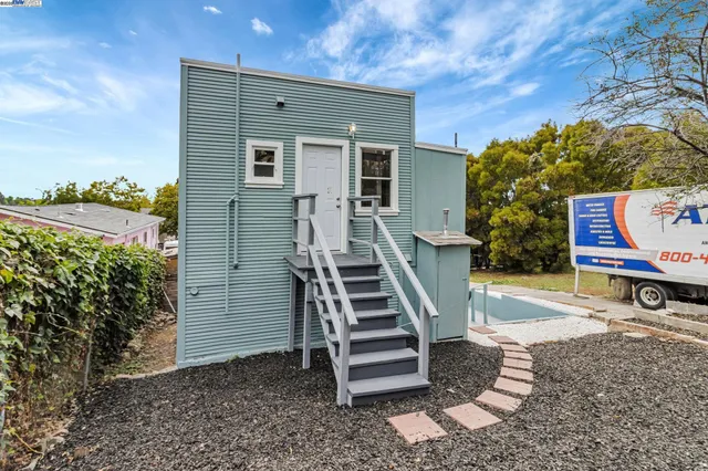 a view of a house with backyard and sitting area