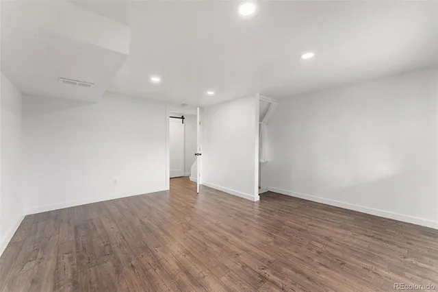 a view of an empty room with wooden floor