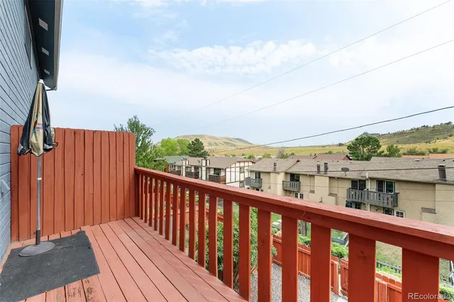 a view of a balcony with wooden floor and fence