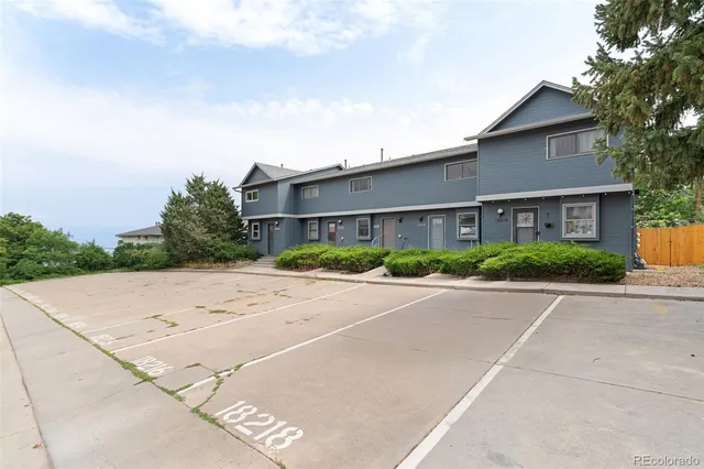 front view of a house with a yard and a trees