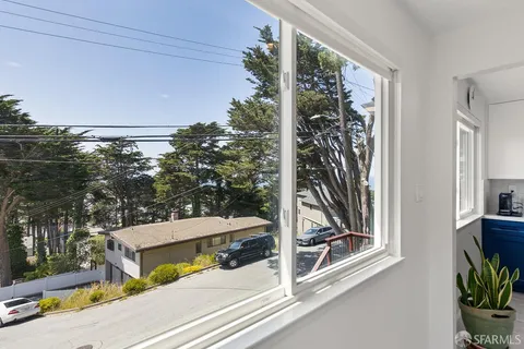 a view of a balcony with floor to ceiling windows and wooden fence
