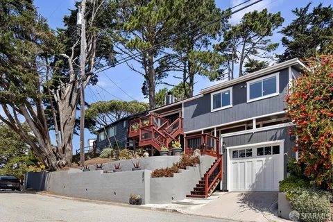 a front view of a house with a tree