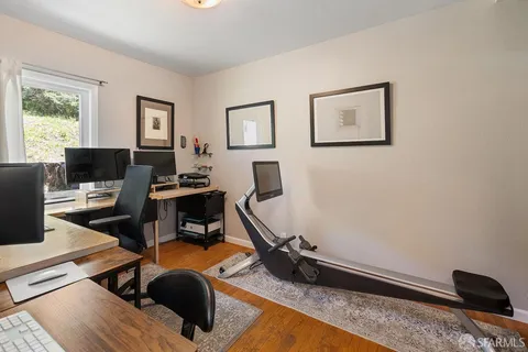 a view of a workspace with furniture and a window
