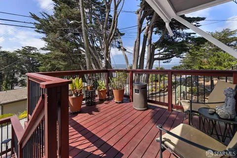 a view of a balcony with chairs and wooden floor