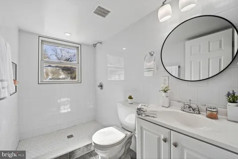 a bathroom with a toilet a sink and mirror