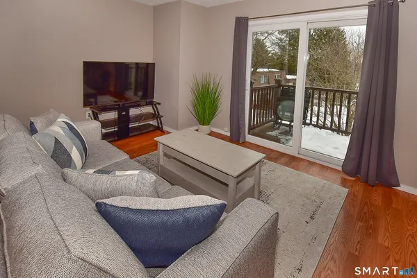 a living room with furniture a floor to ceiling window and a flat screen tv